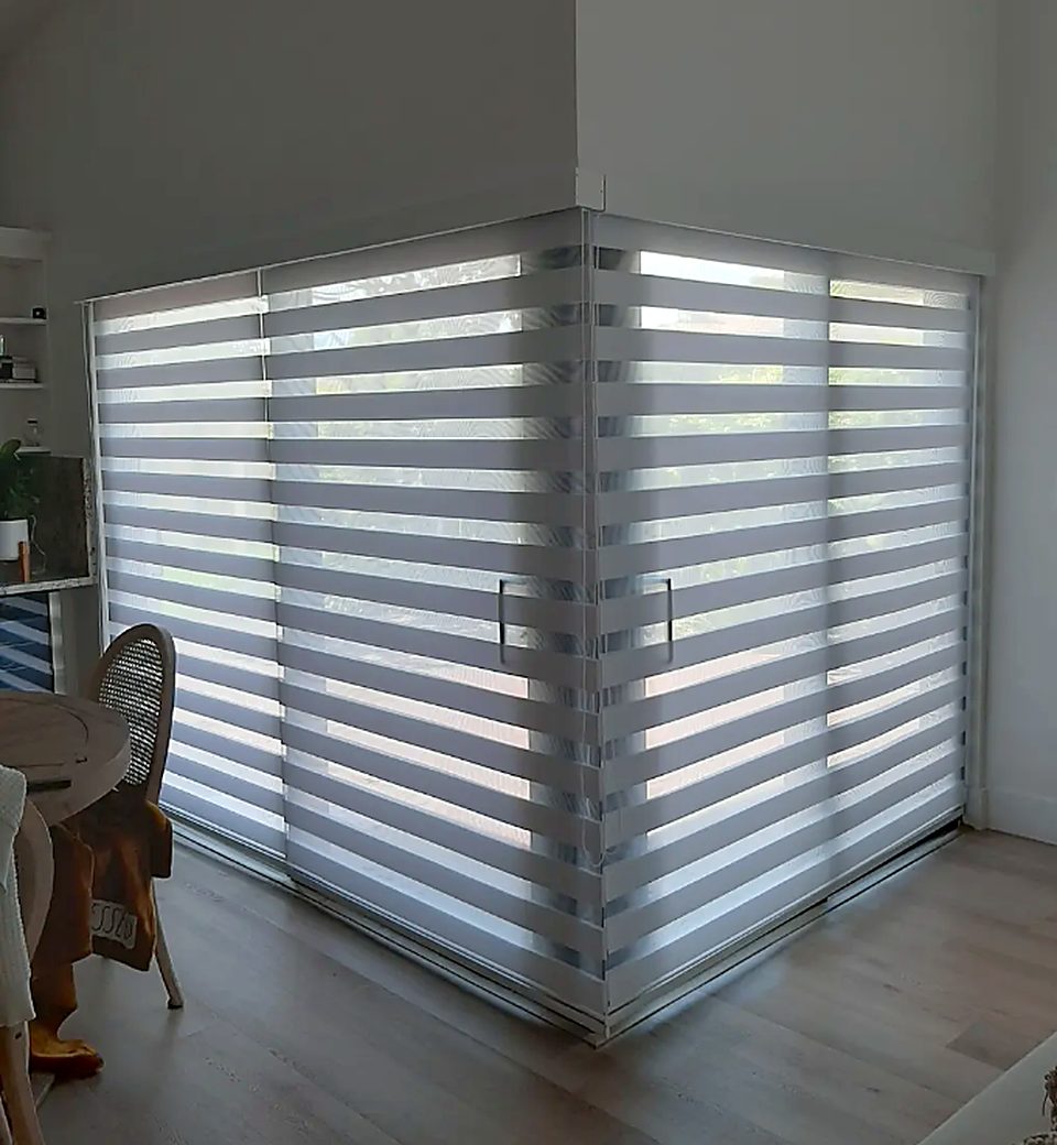 Zebra shades wrapping a corner slider — dining room