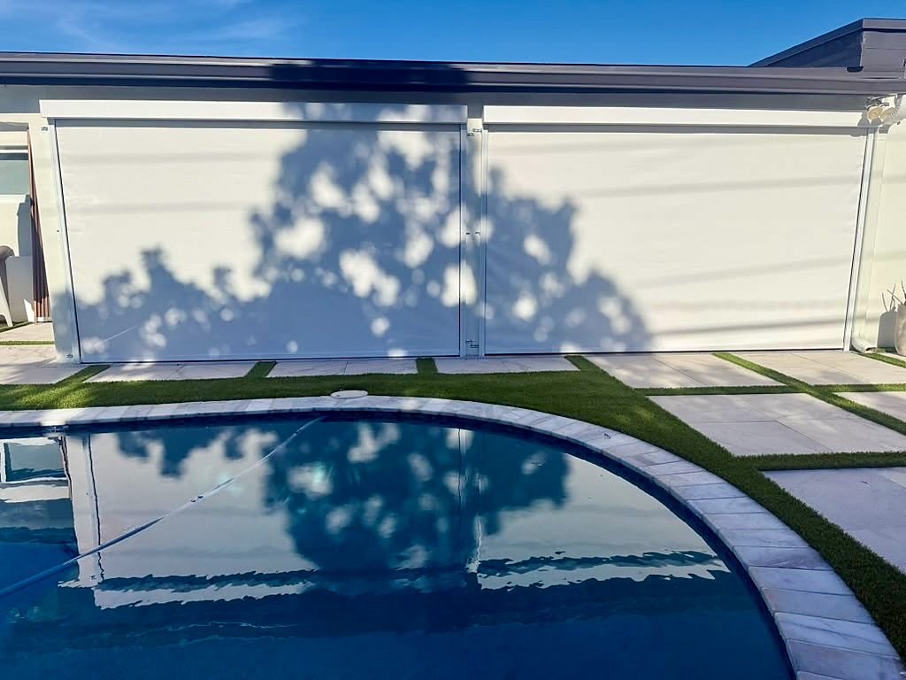 Ivory screens by the pool, tree shadow across the fabric